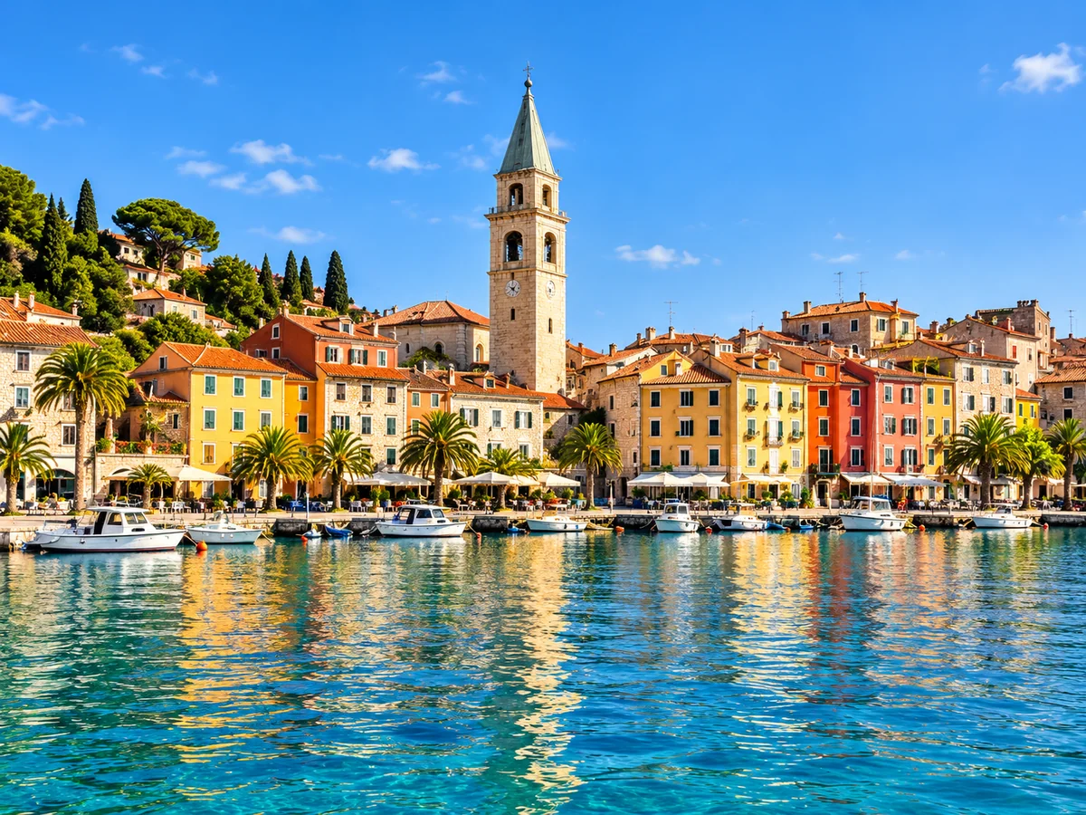 An illustrative coastal harbour with colourful buildings and a historic bell tower.
